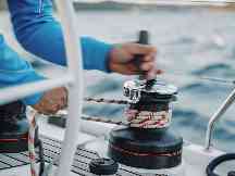 Gothaer Skipperhaftpflicht: Ein Skipper auf seinem Segelboot holt das Segel ein